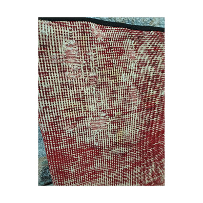 Close view of ivory linear traces and soft blush accents across the muted-red wool surface