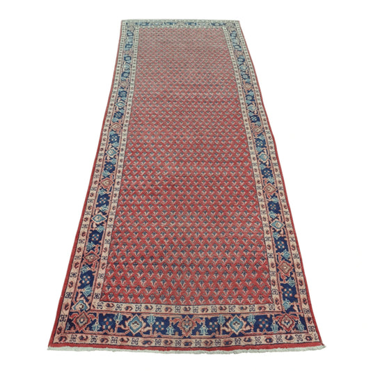 Full view of Vintage Persian Sarouk Mir Boteh wool runner rug with red patterned field and blue border, 355 x 135 cm