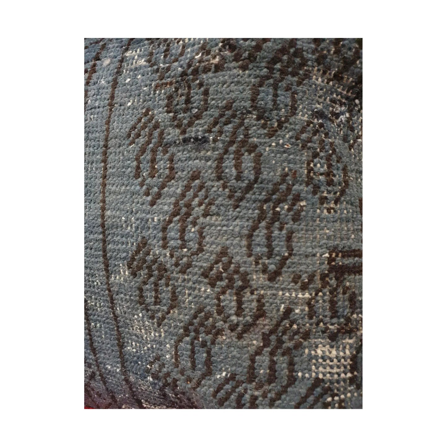 Close-up of dark brown floral motifs and softened pattern across the slate blue Persian cushion cover