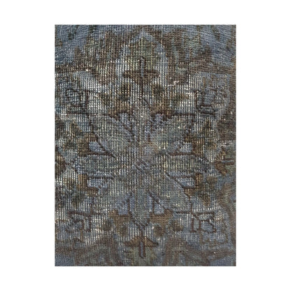 Close-up of smoky blue wool pile with a dark brown medallion and faded ivory pattern traces
