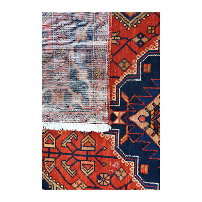 Folded-corner detail of Persian Zanjan rug showing the reverse weave, geometric front design and pale fringe