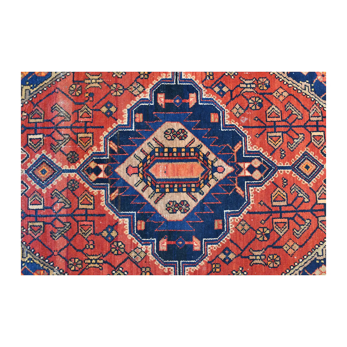 Close-up of the Zanjan rug’s geometric medallion with an ivory centre, dark navy outline and brick-red field