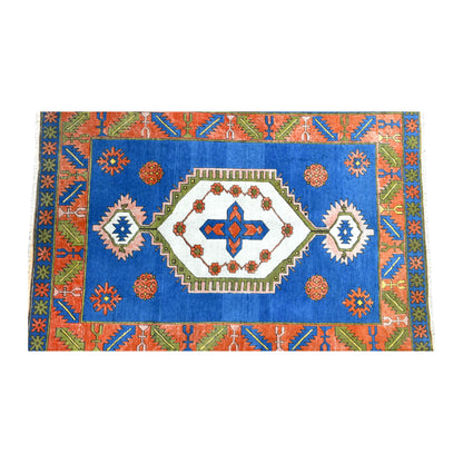 Field detail of vintage Turkish Anatolian rug showing its elongated ivory medallion and scattered rosettes on cobalt blue