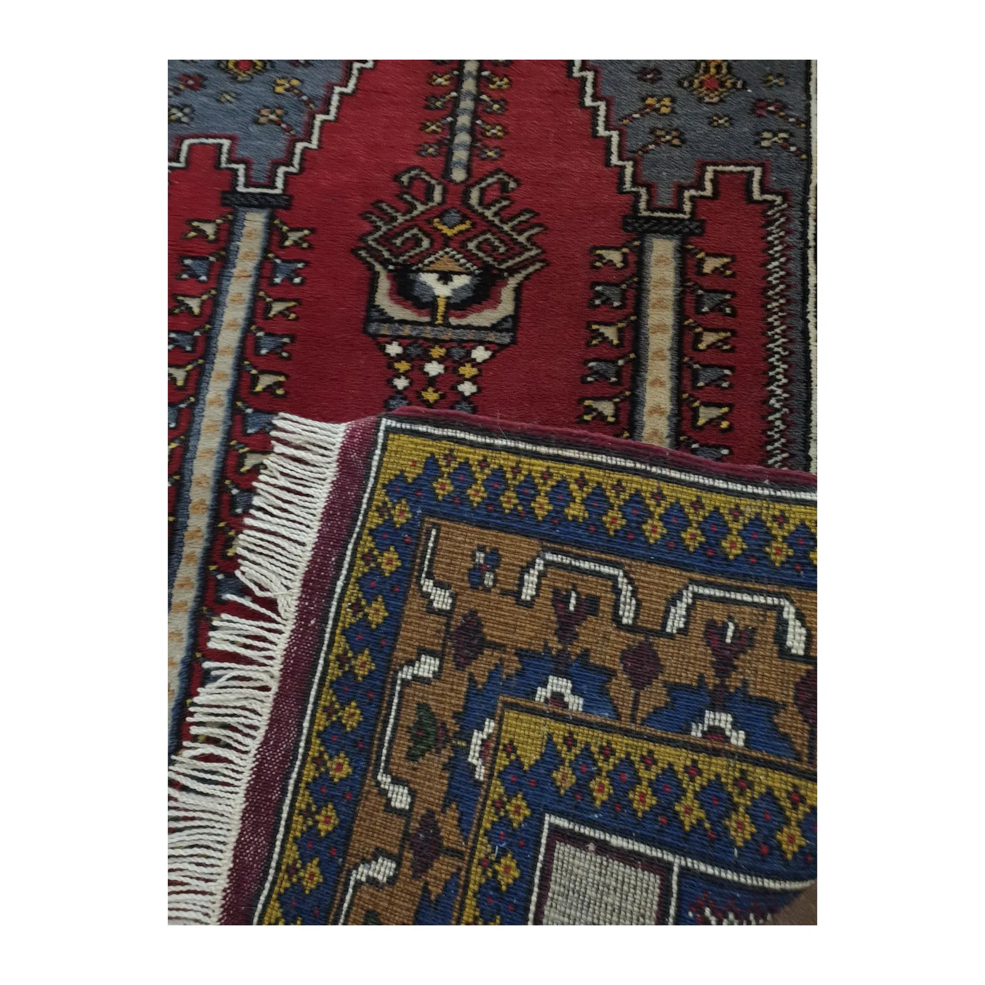 Reverse and fringe detail of a vintage Turkish Kula hand-knotted wool rug showing weave structure and border pattern
