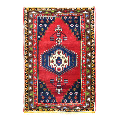Full view of vintage Turkish Yahyali hand-knotted wool rug with red field, ivory-centred navy medallion and patterned borders, 232 x 120 cm