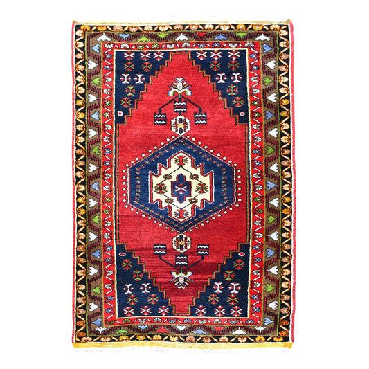 Full view of vintage Turkish Yahyali hand-knotted wool rug with red field, ivory-centred navy medallion and patterned borders, 232 x 120 cm