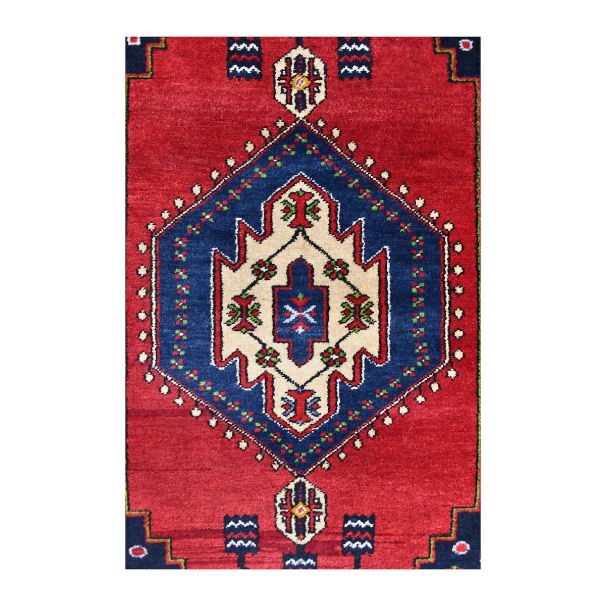 Close-up of the Yahyali rug’s ivory medallion within a navy diamond on the red field