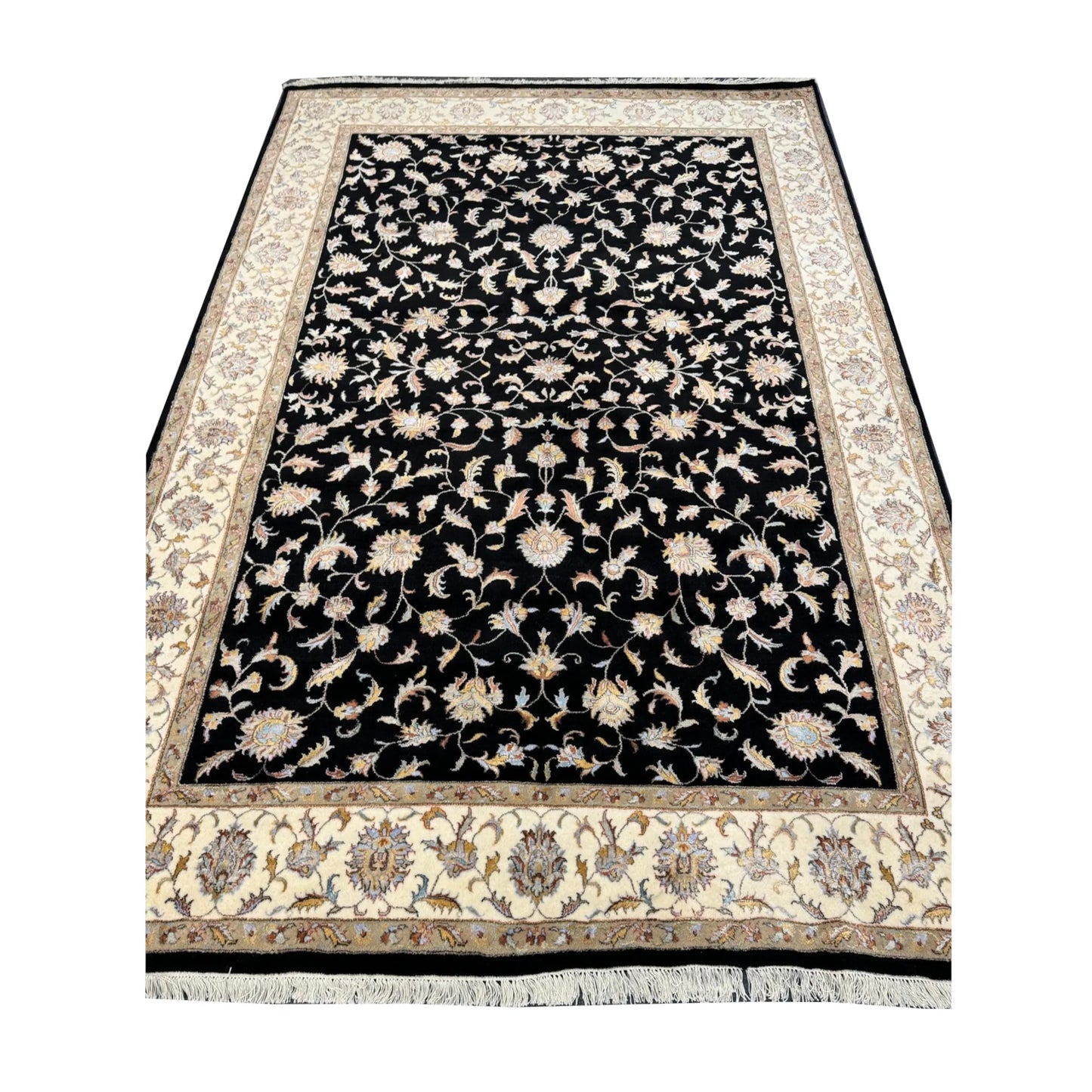 Fringe-end perspective view of black Ziegler rug showing the floral field and beige border